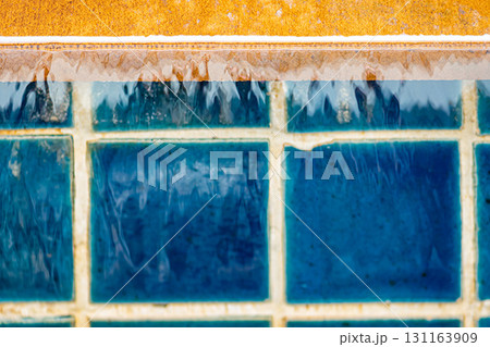 Running pool water in blue bricks background Running pool water in blue bricks background 131163909