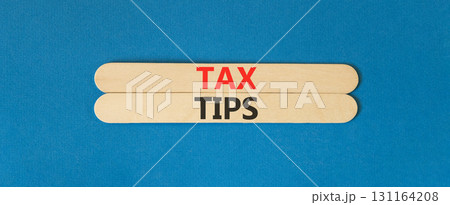 Tax tips symbol. Concept word Tax tips on beautiful wooden sticks. Beautiful blue paper background. Business tax tips concept. Copy space. Tax tips symbol. Concept word Tax tips on beautiful wooden sticks. Beautiful blue paper background. Business tax tips concept. Copy space. 131164208