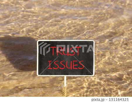 Trust issues symbol. Concept word Trust issues on beautiful black blackboard. Beautiful Red sea water background. Black blackboard. Business trust issues concept. Copy space. 131164325