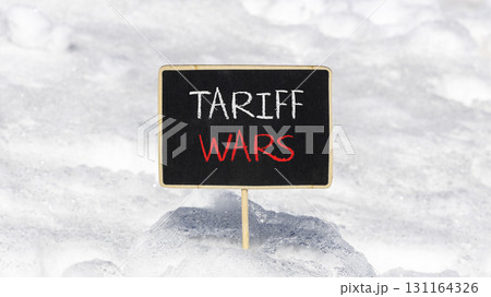 Trade tariff wars symbol. Concept word Tariff wars on beautiful black blackboard. Beautiful white snow background. White snow. Black blackboard. Business trade tariff wars concept. Copy space. Trade tariff wars symbol. Concept word Tariff wars on beautiful black blackboard. Beautiful white snow background. White snow. Black blackboard. Business trade tariff wars concept. Copy space. 131164326