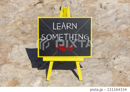 Learn something new symbol. Concept words Learn something new on beautiful blackboard. Beautiful brown stone beach background. Business motivational lifestyle learn something new concept. Copy space 131164334