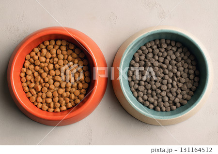 Two bowls filled with dry pet food, top view 131164512