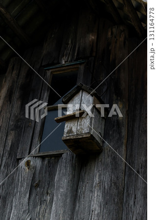 Very Old Gray Nesting Box Hanging on the Wooden Gray Barn Wall 131164778