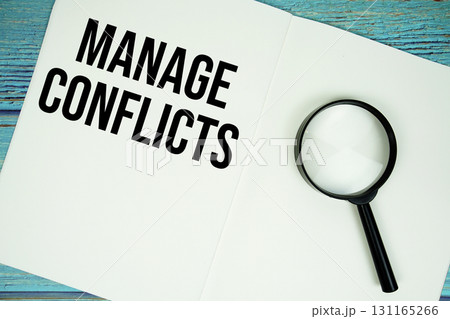 Manage Conflicts text written on notepad with magnifying glass flat lay on wooden background 131165266