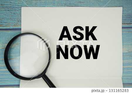Ask Now text written on notepad with magnifying glass flat lay on wooden background 131165283