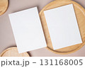 Empty white blank greeting or invitation card, wooden plate on beige background. 131168005