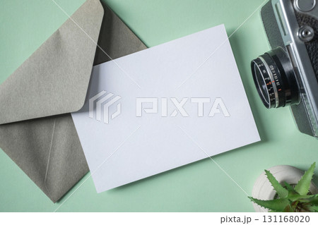 Empty white blank greeting or invitation card, envelope, vintage camera, cactus on green background. Empty white blank greeting or invitation card, envelope, vintage camera, cactus on green background. 131168020