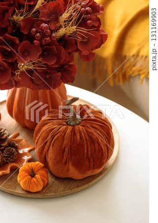 Thanksgiving living room decor with a coffee table, pumpkins and a floral arrangement. Thanksgiving living room decor with a coffee table, pumpkins and a floral arrangement. 131169903