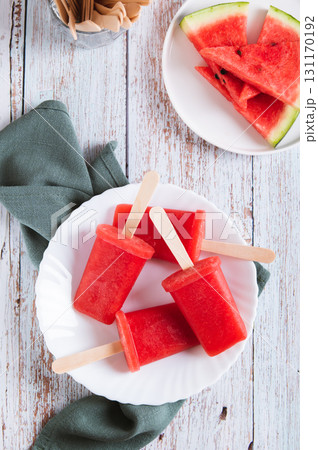 Red watermelon popsicle ice cream on a plate on the table top and vertical view Red watermelon popsicle ice cream on a plate on the table top and vertical view 131170192