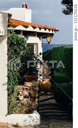 Mediterranean style house corner with white walls terracotta roof green plants 131170228