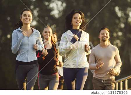 Group of young 30s men and women jogging outdoors 131170363