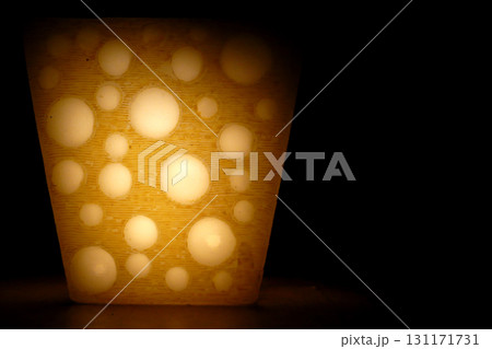 candle in the shape of yellow cheese shine with a fire light 131171731