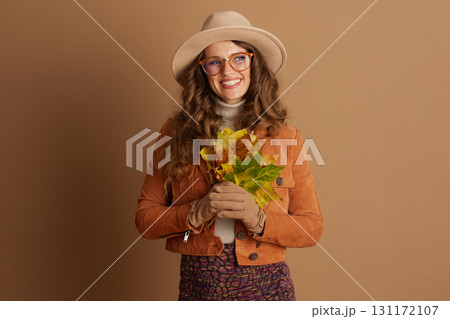 Cheerful Woman Showcasing Autumn Foliage and Style Cheerful Woman Showcasing Autumn Foliage and Style 131172107