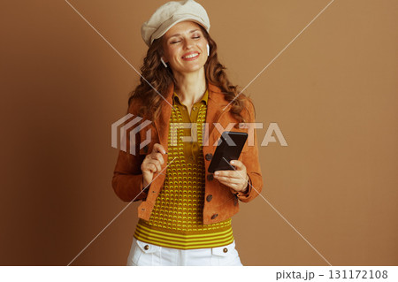 Woman Enjoying Audio on Smartphone in Autumn Style 131172108