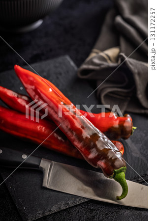 Corno di Toro Rosso pepper. Red paprika vegetable on black table. 131172257