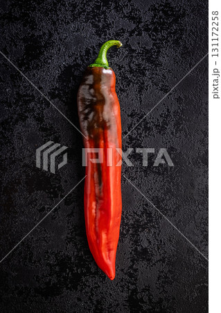 Corno di Toro Rosso pepper. Red paprika vegetable on black table. Top view. Corno di Toro Rosso pepper. Red paprika vegetable on black table. Top view. 131172258