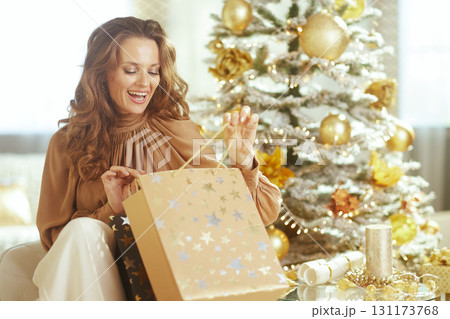 Excited Woman Opening Christmas Gift Bag 131173768