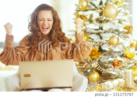 Excited Woman Celebrating Triumph with Laptop Excited Woman Celebrating Triumph with Laptop 131173787