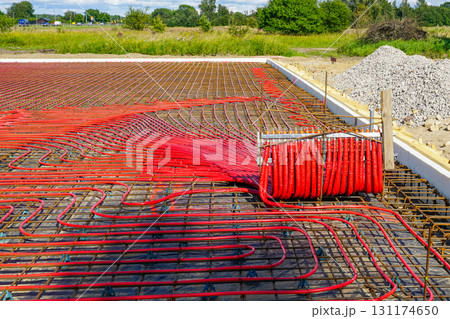 Red underfloor heating pipes installed in reinforced insulated concrete slab foundation frame Red underfloor heating pipes installed in reinforced insulated concrete slab foundation frame 131174650