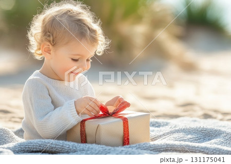Smiling child with gift at beach during christmas celebration 131175041