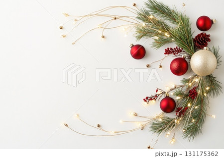 Festive christmas garland with red and gold ornaments, pinecones, and twinkling lights 131175362