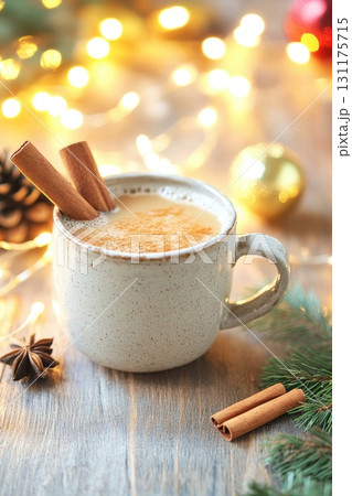 Cozy holiday mug of eggnog with cinnamon sticks and festive lights 131175715
