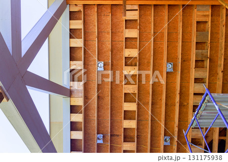 Workers are renovating an interior space, revealing wooden ceiling structure beams supports frame scaffolding for support. Workers are renovating an interior space, revealing wooden ceiling structure beams supports frame scaffolding for support. 131175938