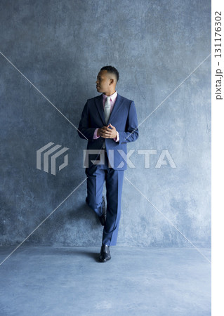 壁に立っているスーツを着た男性 壁に立っているスーツを着た男性 131176302