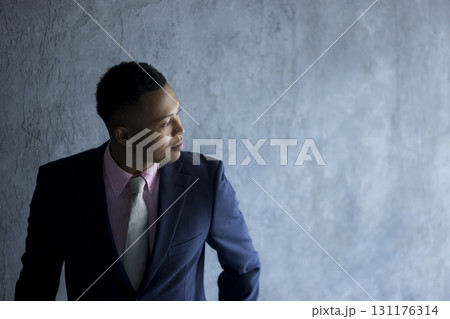 壁に立っているスーツを着た男性 131176314