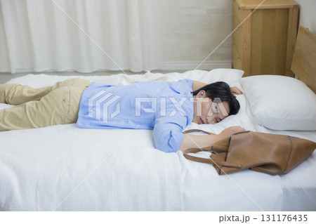 ベッドに倒れ込む男性 ベッドに倒れ込む男性 131176435