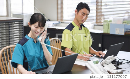 電話対応をするアジア人介護士 131177097
