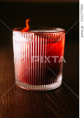 Negroni glass. Alcoholic drink. Red cocktail served with citrus slice peel. Aromatic refreshing liquor mix in glowing faceted tumbler. Negroni glass. Alcoholic drink. Red cocktail served with citrus slice peel. Aromatic refreshing liquor mix in glowing faceted tumbler. 131177892
