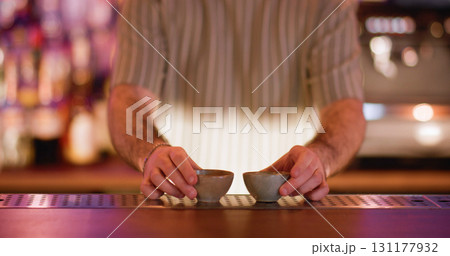 Sake cup. Serving alcoholic drink. Barkeeper putting on counter little empty clay bowls for traditional asian beverage. Ceramic dishes for rice wine. Sake cup. Serving alcoholic drink. Barkeeper putting on counter little empty clay bowls for traditional asian beverage. Ceramic dishes for rice wine. 131177932