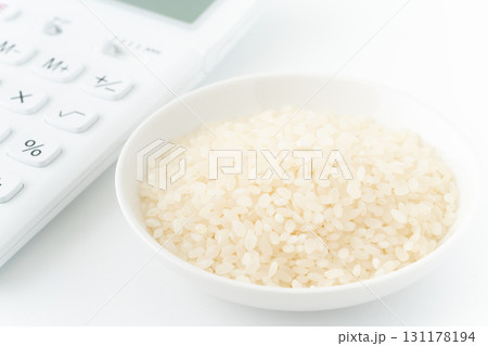 電卓とお皿に入った白米のクローズアップ 電卓とお皿に入った白米のクローズアップ 131178194