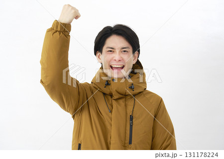 ダウンジャケットを着た男性　ガッツポーズ　白背景 131178224