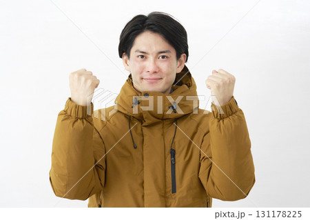 ダウンジャケットを着た男性　ガッツポーズ　白背景 131178225