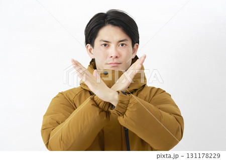 ダウンジャケットを着た男性　バツ印のジェスチャー　白背景 131178229