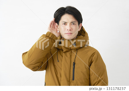 ダウンジャケットを着た男性 耳に手を当てて聴く 白背景 ダウンジャケットを着た男性 耳に手を当てて聴く 白背景 131178237
