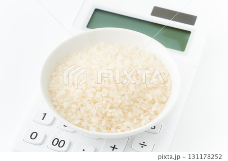 電卓の上に載ったお皿に入った白米のクローズアップ 131178252