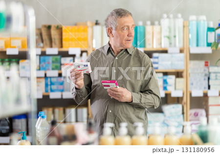 Senior man choosing pain or fever relief medicine in pharmacy Senior man choosing pain or fever relief medicine in pharmacy 131180956