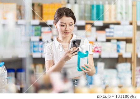 woman scans a mouthwash on her phone woman scans a mouthwash on her phone 131180965