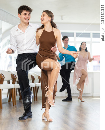 Enthusiastic young girl and guy rehearsing upbeat jive in dance studio Enthusiastic young girl and guy rehearsing upbeat jive in dance studio 131181331