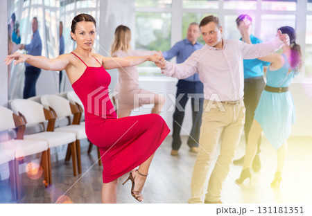 Happy woman enjoying active dancing in pair in dance studio Happy woman enjoying active dancing in pair in dance studio 131181351