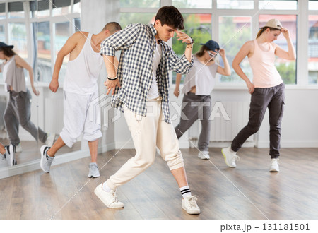 Stylishly dressed young people learn to dance hip-hop and breakdance in dance studio Stylishly dressed young people learn to dance hip-hop and breakdance in dance studio 131181501