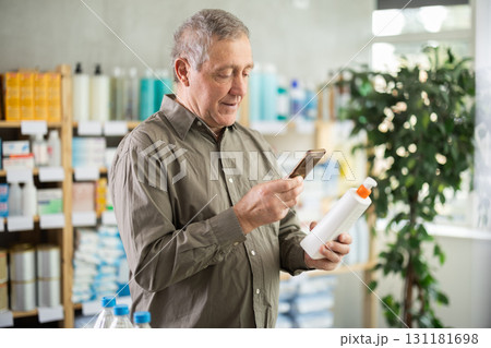 Senior man in pharmacy scans QR code on atopic cream Senior man in pharmacy scans QR code on atopic cream 131181698