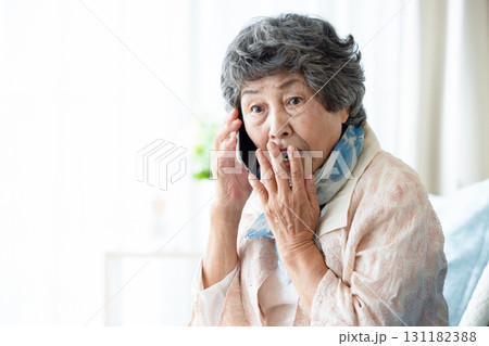不審な電話に出るシニア女性 不審な電話に出るシニア女性 131182388