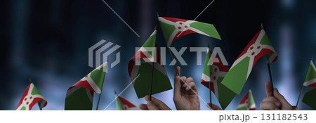 Burundi flags in their hands on a blurred urban background 131182543