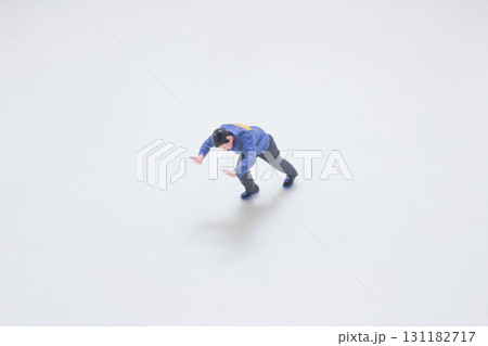 Miniature Toy Figure in Blue Jacket Performing a Stretch Pose 131182717