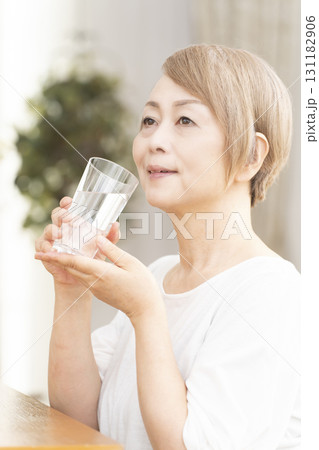 リビングで水を飲むシニア女性 リビングで水を飲むシニア女性 131182906
