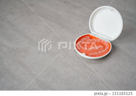 歯科矯正用のアライナーが入っているオレンジ色と白色のケース 131183125